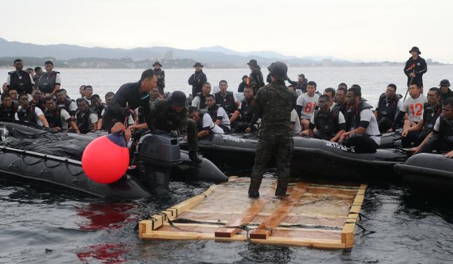 1 C-130 수송기에서 강하한 특전요원들이 고무보트에 올라탄 뒤 낙하산을 수거하고 있다. 2 C-130 수송기에서 공중 강하한 특전요원들이 고무보트를 이용해 육지로 접안하고 있다. 3 특전요원들이 C-130 수송기에서 투하한 물자 해체 교육을 받고 있다. 4 해상척후조 훈련에 참가한 특전요원들이 해안을 달리며 체력단련을 하고 있다. 사진=양동욱 기자