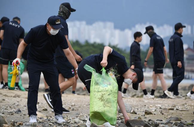 해군진해기지사령부 시설전대 장병들이 5일 경남 창원시 진해구 속천항 인근에서 집중호우와 강풍 등에 밀려온 쓰레기를 수거하고 있다.  사진 제공=신승우 하사