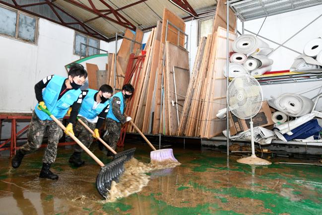 5일 공군2방공유도탄여단 장병들이 집중호우로 피해를 본 충남 천안시 신당동 일대 상가 지역에서 침수 피해 복구 작업을 하고 있다.  부대 제공 