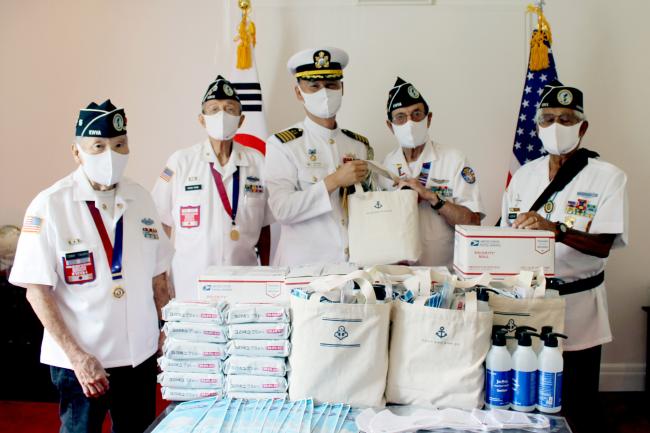지난 6일(현지시간) 미국 주하와이 총영사관 무관부에서 진행된 6·25전쟁 미군 참전용사를 위한 물품 전달행사에서 김정일(대령·가운데) 해군무관이 미군 참전용사들에게 코로나19 방역물품을 전달한 뒤 기념사진을 찍고 있다.  부대 제공