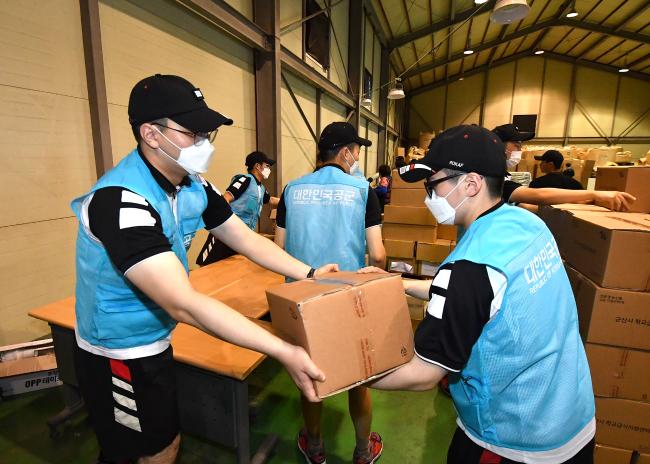 공군38전투비행전대 장병들이 전북 군산시 급식지원센터를 방문, ‘농산물 가족 꾸러미’ 제작에 참여하고 있다.  사진 제공=구현성 일병