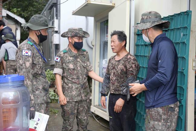 황인권(왼쪽 둘째) 육군2작전사령관이 최근 집중호우로 큰 피해를 본 경남 하동군 피해 복구 현장을 찾아 지역주민을 위로하고 있다.  부대 제공