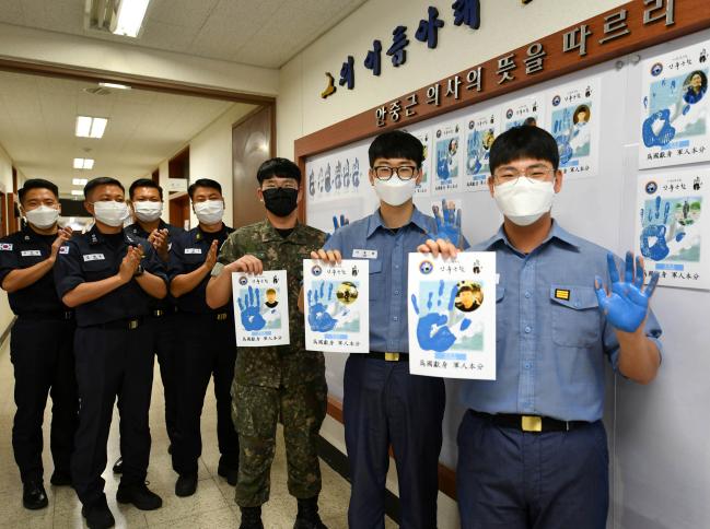 해군잠수함사령부 안중근생활관 영내 장병이 13일 광복절을 앞두고 안중근함 육상 사무실 통로에 마련된 게시판에 앞에서 ‘손바닥 도장 찍기’ 행사에 참여하고 있다.  부대 제공 