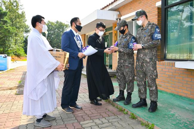 공군2방공유도탄여단 ‘장병 스트레스 해소·사기 진작 위한 위문 행사’에서 군종실에 사연을 보낸 군사경찰대 전광휘 상병과 장병들이 위문품을 전달받고 있다. 
 사진 제공=홍진수 하사