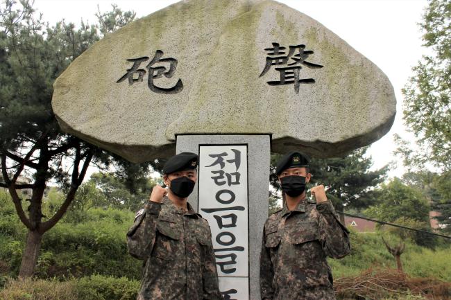 육군수도포병여단 백선호·백규민 하사(왼쪽부터)가 부대 상징탑 앞에서 포즈를 취하고 있다.  부대 제공