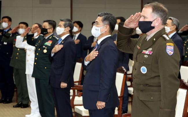 18일 서울 용산구 국방부 대회의실에서 열린 '제46·47대 국방부 장관 이·취임식'에서 신임 서욱 장관과 전임 정경두 장관 등 참석자들이 국기에 경례하고 있다. 