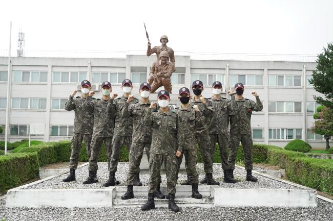 육군훈련소 최고의 전투기술 시범왕 최우수 타이틀을 차지한 송명진(맨 앞)·박인환(둘째줄 왼쪽) 상병과 우수 조교들이 파이팅을 외치며 기념사진을 찍고 있다. 사진 제공=최용호 하사