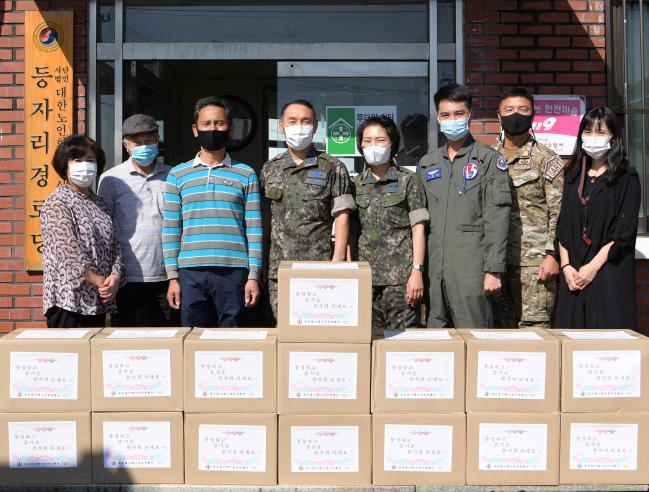 공군15특수임무비행단이 한가위를 맞아 부대 인근 지역인 성남 수정구 등자리 경로당을 방문해 위문품을 전달했다. 사진은 15비 감찰안전실 장병들과 등자리 주민대표들이 기념사진을 찍는 모습.  사진 제공=김샛별 중사