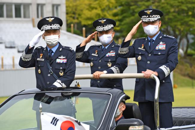 이성용(오른쪽) 공군참모총장이 23일 계룡대 대연병장에서 거행된 ‘제37·38대 공군참모총장 이·취임식’에서 서욱 국방부 장관으로부터 지휘권을 상징하는 공군기를 전달받고 있다.  공군 제공