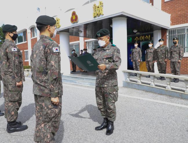 신희현 육군36사단장이 사단 본청 앞에서 열린 백호 장학금 수여식에서 모범용사들에게 장학증서·장학금·휴가증을 수여하고 있다.  부대 제공