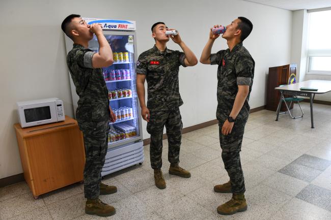 1일 음료수 냉장고를 보급받은 해병대 1사단 장병들이 냉장고 안에서 음료수를 꺼내 마시고 있다. 국방부는 이달 말까지 전 군에 1만 2000여 대의 음료수 냉장고를 보급할 계획이다.  국방부 제공