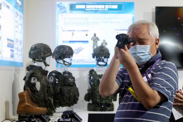 한 관람객이 육군 아미타이거 홍보 부스에서 워리어 플랫폼 장비를 확인하고 있다.