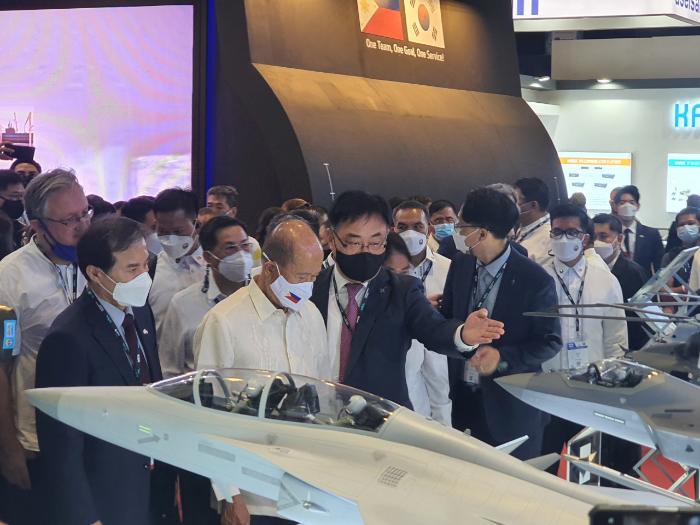 지난 4월 개최된 필리핀 국제방위산업전시회에서 이봉근(앞줄 오른쪽) 한국항공우주산업(KAI) 수출혁신센터장이 델핀 로렌자나(앞줄 가운데) 필리핀 국방장관에게 국산 군용기를 설명하고 있다.  KAI 제공