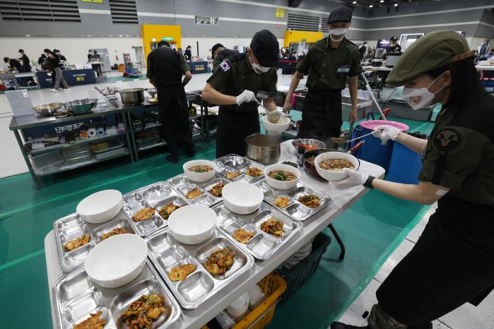 그릇에 음식을 담는 육군5포병여단 ‘설국열차’ 팀 장병들.