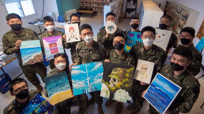 육군3포병여단 금강대대 ‘ART 솔져’ 미술동아리 장병들이 각자 그린 그림을 들고 포즈를 취하고 있다.