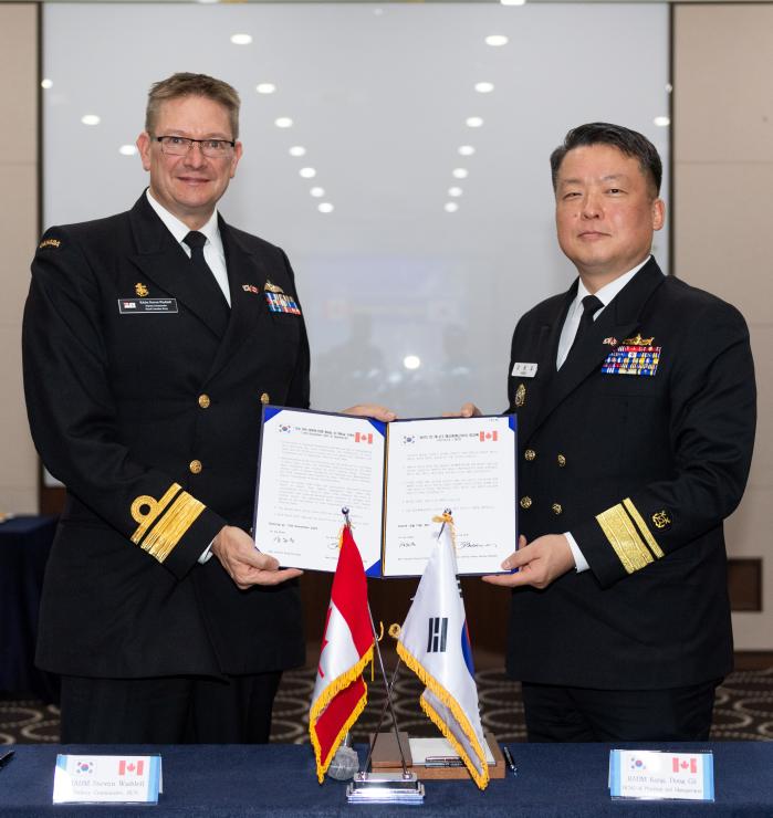 한국-캐나다 해군 대 해군회의에서 강동길(소장·오른쪽) 해군본부 기획관리참모부장과 스티븐 웨델(소장) 캐나다 해군사령부 부사령관이 회의록을 들고 포즈를 취하고 있다.  해군 제공