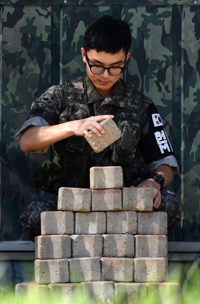 한 병사가 GOP 철수일자를알려주는 ‘완전경계 완수탑’의 벽돌을 제거하고 있다