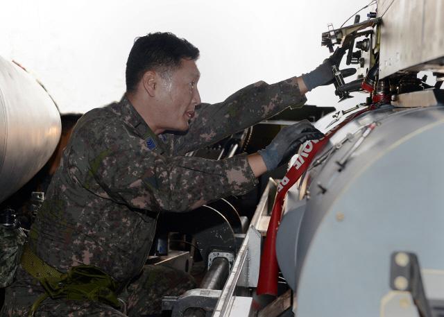 공군10전투비행단이 전투태세 훈련의 하나로 실시한 최대 무장 장착 훈련에서 무장정비사가 F-4E 전투기에 최대량의 무장을 신속하게 장착하고 있다.  사진 제공=오규민 원사