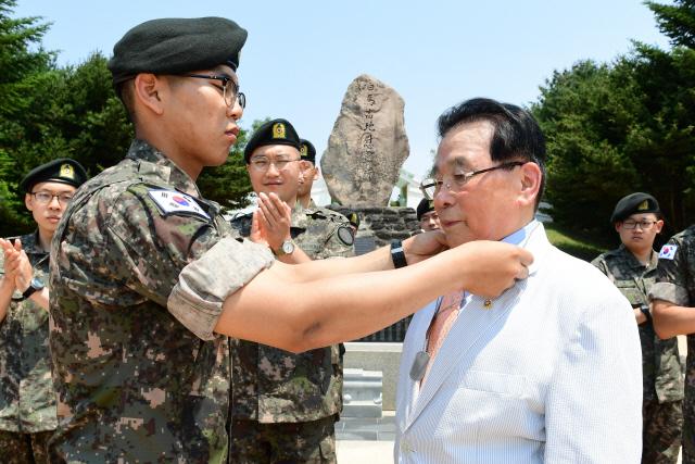 
2017년 6월 16일 강원도 철원군 백마고지 전적지에서 박명호 백마고지참전전우회장의 친손자인 박희태 이병이 박 회장의 이름과 군번이 적힌 인식표를 할아버지에게 전달하고 있다. 박 회장이 인식표를 분실해 부대에서 새롭게 제작 후 전달했다.    국방일보 DB