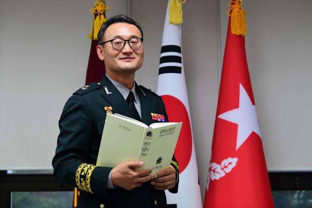 이동호 육군 법무실장이 국방일보 장군의 서재 추천도서인 『권력의 법칙』을 들고 미소를 지어 보이고 있다. 조종원 기자