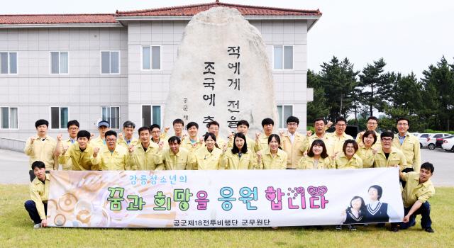 공군18전투비행단 군무원단이 강릉시와 조손가정 아동 후원 협약을 체결하고 ‘지역과 소통하는 비행단, 신뢰받는 비행단’ 만들기를 다짐하며 기념촬영을 하고 있다. 
 사진 제공=이태화 상병