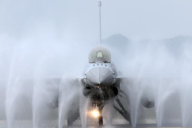 전국적인 폭염이 이어지고 있는 23일 충북 충주 공군19전투비행단 유도로에서 임무를 마친 F-16 전투기가 작전 중 묻은 염분 등 이물질로 인한 기체의 부식을 방지하기 위해 린스(CWR:Clear Water Rinse) 작업을 받고 있다.  사진=한재호 기자