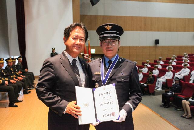 서주석(왼쪽) 국방부 차관이 임관 대표자인 전성용 대위(공군)에게 임관사령장을 수여한 후 기념사진을 찍고 있다.  부대 제공