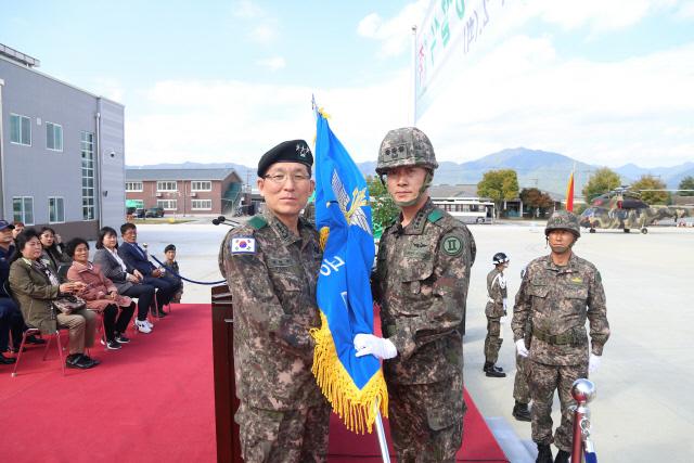 지난 2일 열린 육군12항공단 창설식 행사에서 김혁수(중장·왼쪽) 2군단장이 김승수(대령) 12항공단장에게 부대기를 전달하고 있다.  부대 제공