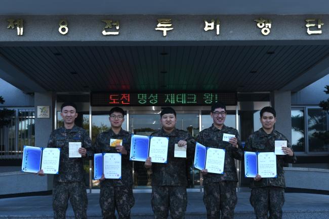 공군8전비 재테크 왕에 선정된 장병들이 상장과 통장을 들고 기념 사진을 찍고 있다.  부대 제공