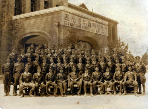 조선경비대 1연대 장병들이 ‘조선경비대’ 현판이 붙은 건물 앞에서 기념사진을 찍는 모습.
