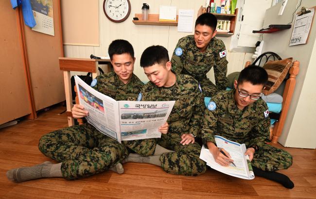 동명부대 장병들이 주둔지 내 생활관에서 휴식을 취하면서 A3종이에 인쇄된 국방일보를 보며 이야기를 나누고 있다. 