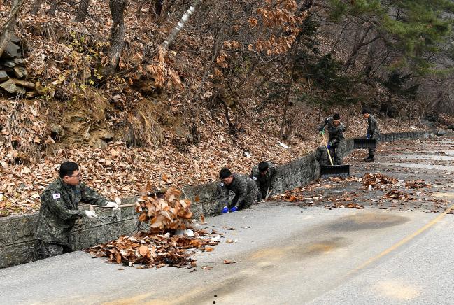 공군19전투비행단 장병들이 27일 충주시 자매결연 아동복지시설을 방문해 진입로 일대의 낙엽을 제거하는 봉사활동을 하고 있다.  사진 제공=한범희 상사 