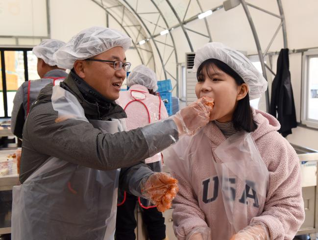 김장하기 체험 행사에 참가한 공군18전비 부대원이 직접 담근 김장김치를 자녀에게 먹여주고 있다.  
 사진 제공=정준우 상병