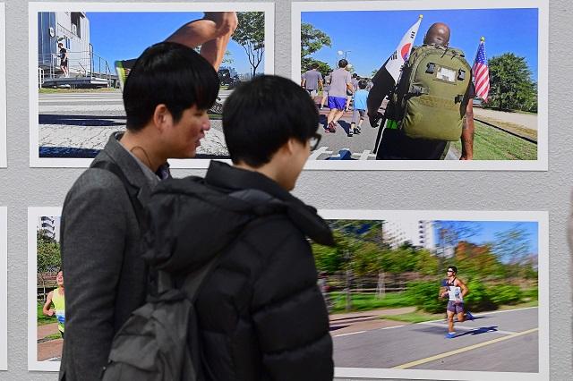 21일 대학로 상명대 예술디자인센터 갤러리에서 막을 올린 시각장애인과 함께하는 '사진전 2018 마음으로 보는 세상'을 찾은 관람객들이 국방일보 전우마라톤대회를 소재로한 작품들을 살펴보고 있다. 조종원 기자