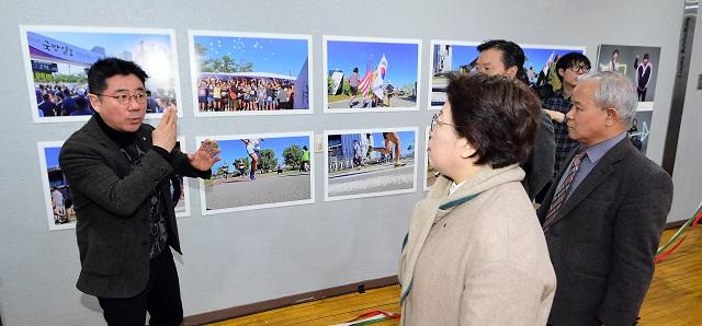 21일 서울 종로구 상명대학교 예술디자인센터에서 열린 2018 시각장애인과 함께하는 사진전시회 ‘마음으로 보는 세상-남대문시장 이야기’의 개막식에서 이붕우 국방홍보원장, 상명대학교 영상·미디어연구소 양종훈 소장을 비롯한 참석자들이 시각장애인들이 찍은 제15회 국방일보 전우마라톤 대회 사진을 살펴보고 있다. 조종원 기자 