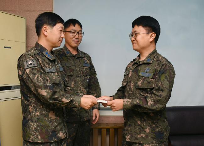지난 26일 공군10전투비행단 오상철(중령) 부품정비대대장이 대대원의 마음이 담긴 성금을 민경찬 중사에게 전달하고 있다.  사진 제공=오규민 원사