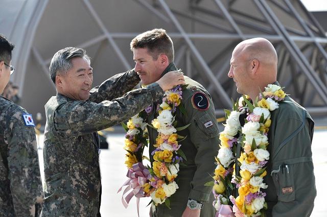 지난달 29일 공군 청주기지에서 열린 대한민국 최초의 스텔스 전투기 F-35A 도입 환영행사에서 이왕근 공군참모총장이 미국에서 한국까지 전투기를 조종해 온 미 공군 마이클 홉슨 소령과 제이슨 월 소령에게 화환을 걸어주고 있다.             공군 제공