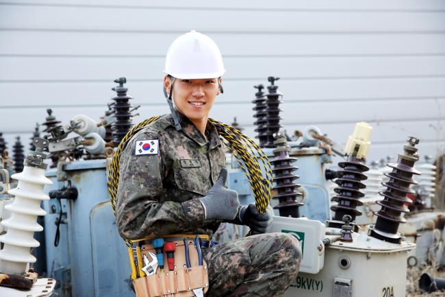 육군5기갑여단 공병대 장원석 병장이 전신주 전기설비작업 중 휴식을 취하면서 엄지를 들어보이고 있다.  육군 제공
