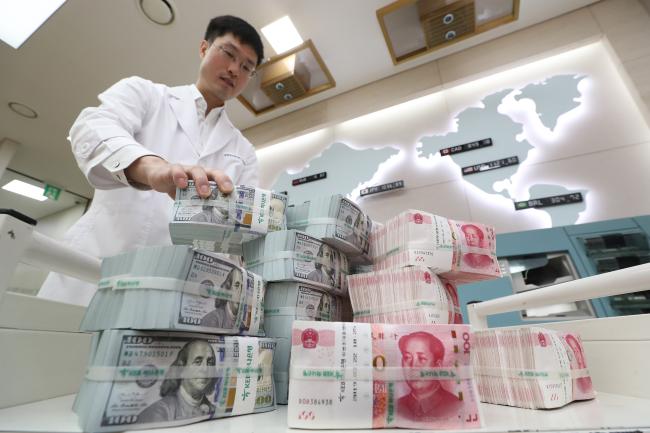세계 1, 2위의 경제대국인 미국과 중국의 무역 갈등이 심화되면서 글로벌 금융시장의 불안감이 커지고 있다. 사진은 KEB하나은행 위변조대응센터에서 관계자가 미국 달러와 중국 위안화를 정리하는 모습.   연합뉴스 