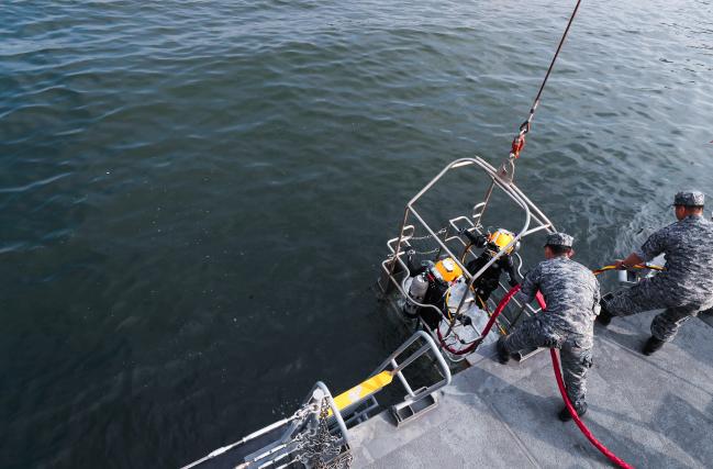 표면공급잠수체계 장비를 착용한 이 홍보위원이 잠수사를 해저로 안내해 줄 구조물인 ‘다이버 스테이지’에서 감독관의 지시에 따라 하잠하고 있다. 이경원 기자 