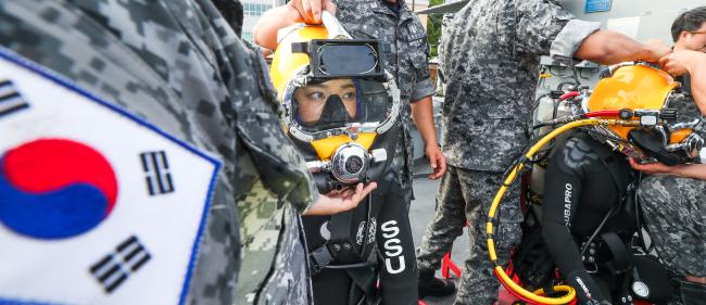 이 홍보위원이 표면공급잠수체계 체험을 위해 14㎏에 달하는 헬멧을 착용하고 있다. 이 홍보위원이 착용한 잠수장비는 총 30㎏에 육박한다. 이경원 기자  
