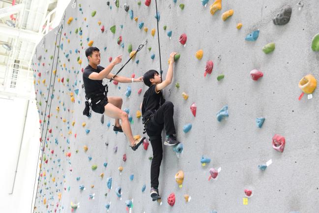 특전사가 여름방학을 맞아 이달 중순까지 운영하는 ‘군 자녀 클라이밍 교실’ 참가 학생이 특전요원의 지도하에 인공암벽을 오르고 있다. 부대 제공