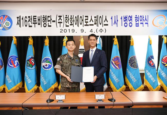 공군16전투비행단장과 한화에어로스페이스 강형석 상무가 4일 1사 1병영 업무협약을 맺은 뒤 기념사진을 찍고 있다.  사진 제공=백승열 상사