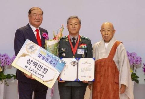 김창수(준장·가운데) 육군1기갑여단장이 지난 7일 ‘제8회 대평 남종현 발명문화상 시상식’에서 장려상을 받은 뒤 그래미 남종현(왼쪽) 회장, 조계종 원로회의 의장 세민 스님과 기념 촬영하고 있다.  부대 제공