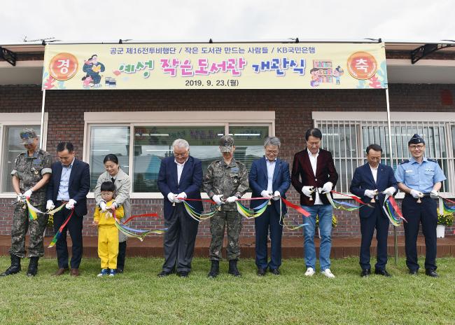 23일 열린 공군16전투비행단 ‘예성 작은 도서관’ 개관식에서 주요 내빈 및 참석자들이 개관 테이프를 자르고 있다.  사진 제공=우동균 하사