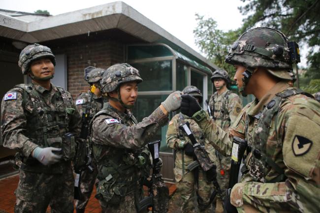 마일즈 전투를 마친 캠프 험프리스 기지방호사령부 본부대 미군 장병과 대항군을 맡은 육군51사단 장병이 주먹을 맞대며 우정을 나누고 있다.  