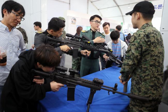 특전사처럼 육군 홍보부스에서 시민과 생도들이 육군특전사 장병들의 총기를 살펴보고 있다. 