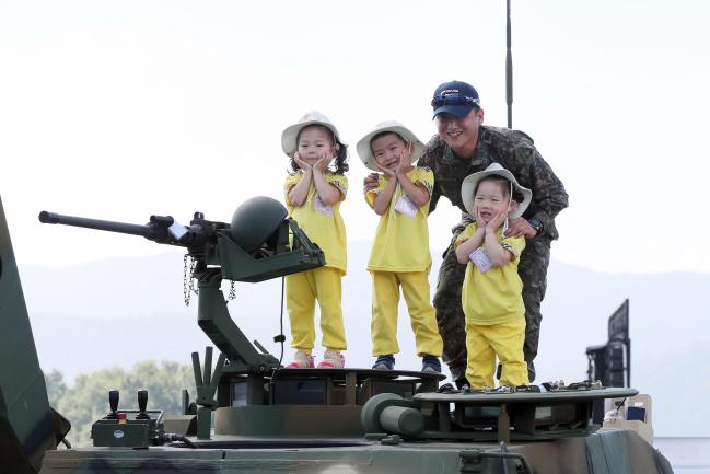 귀엽죠?  행사장을 찾은 어린이들이 육군 장비 위에서 안내 장병과 함께 기념촬영을 하고 있다.