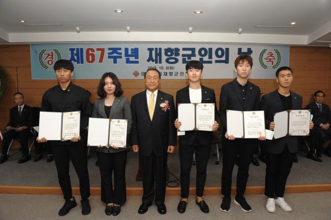 8일 열린 제67주년 재향군인의 날 기념식에서 김진호(왼쪽 셋째) 향군회장이 국가유공자와 참전유공자 자녀에게 장학금을 전달한 뒤 기념사진을 찍고 있다.     향군 제공