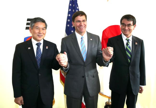 
제6차 아세안 확대 국방장관회의(ADMM-Plus) 참석을 위해 태국을 찾은 정경두(왼쪽) 국방부 장관이 17일 방콕 아바니 리버사이드 호텔에서 열린 한·미·일 국방장관 회담에서 마크 에스퍼(가운데) 미국 국방부 장관, 고노 다로(오른쪽) 일본 방위상과 함께 사진촬영하며 손을 맞잡고 있다. 태국 방콕=조용학 기자
